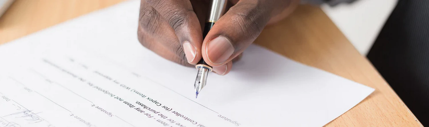 someone with a pen writing on a piece of paper