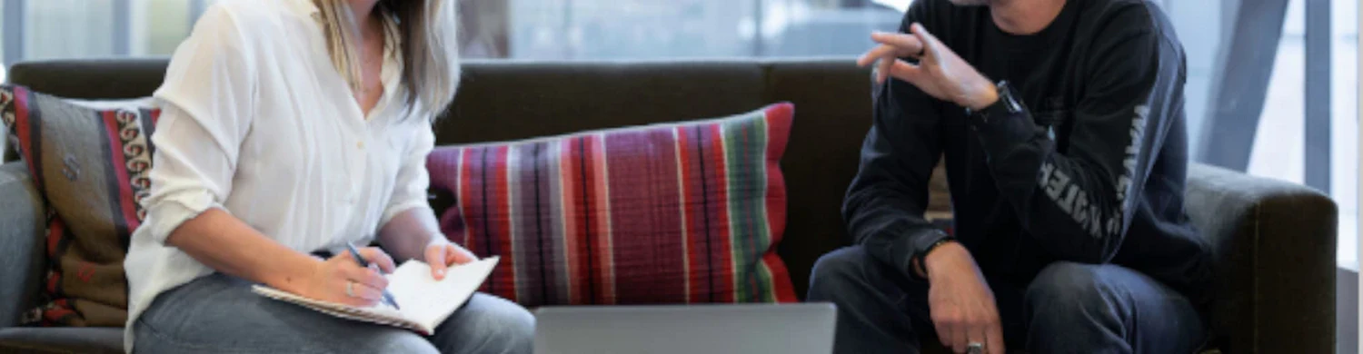 two people sitting on a sofa facing each other